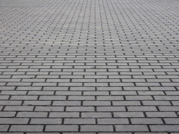 Gray brick paver driveway installed in a running bond pattern for residential property in Parma Heights, OH