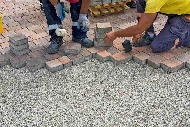 Concrete contractors installing paver driveway edge with gravel base preparation in Shaker Heights, OH
