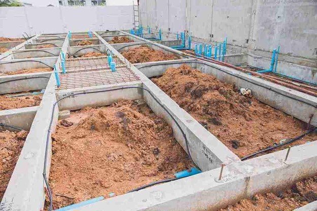Concrete foundation installation with footing layout and plumbing lines prepared for residential build in Shaker Heights, OH