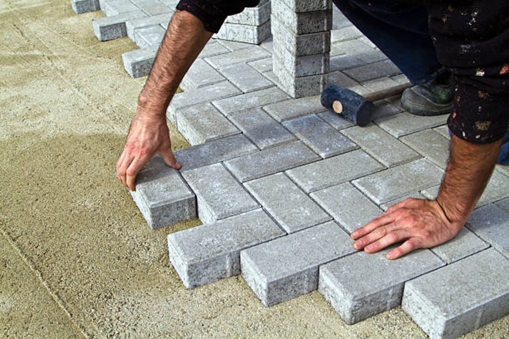 Contractor installing concrete pavers for patio construction on a compacted base in Shaker Heights, OH