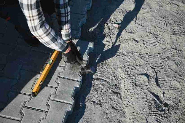 Stamped concrete installation with worker shaping and finishing textured surface in Shaker Heights, OH